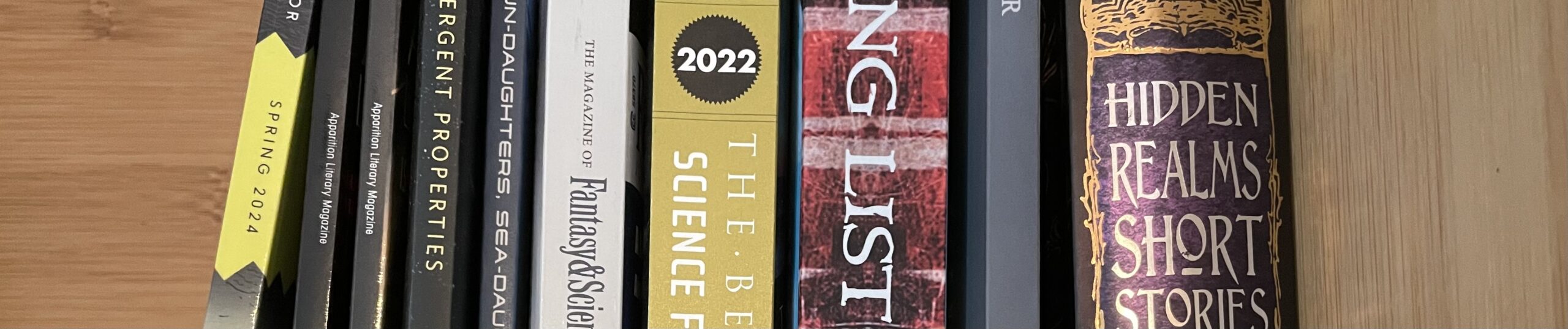 Shelf of books: an issue of Weird Horror, two issues of Apparition Lit, F&SF, 2022 Best American SFF, Long List Anthology, Local Star, and Hidden Worlds collection from Flame Tree Press